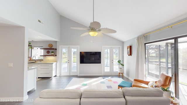 tiled living room featuring sink, french doors, high vaulted ceiling, and ceiling fan