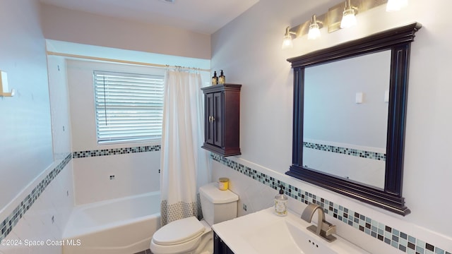 full bathroom with toilet, shower / tub combo with curtain, vanity, and tile walls