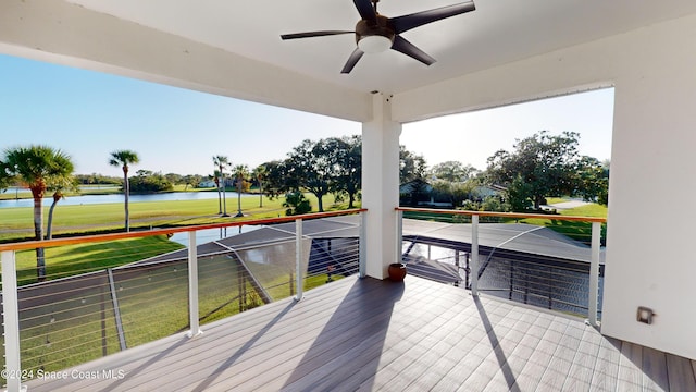 deck featuring a water view, ceiling fan, and a yard