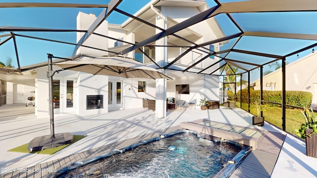 view of swimming pool with pool water feature, a patio, a hot tub, a lanai, and french doors