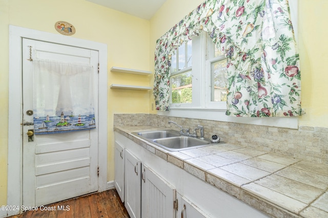 kitchen with tile countertops, decorative backsplash, sink, and dark hardwood / wood-style flooring