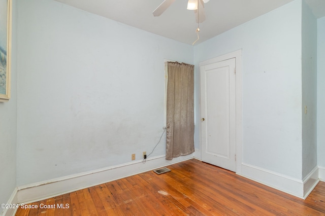 empty room with hardwood / wood-style floors and ceiling fan