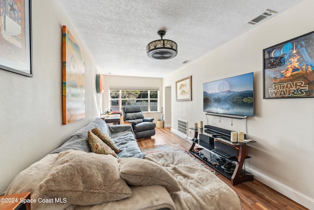 living room featuring hardwood / wood-style flooring and a textured ceiling