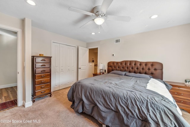 bedroom featuring a closet, ceiling fan, and light carpet