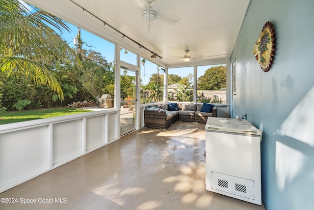 unfurnished sunroom with ceiling fan