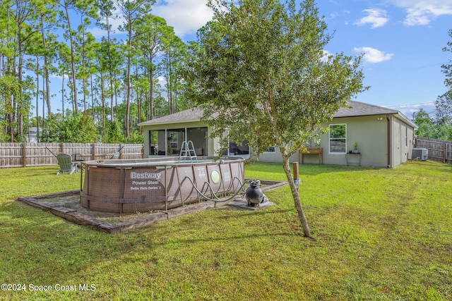 view of yard with a fenced in pool and central AC unit