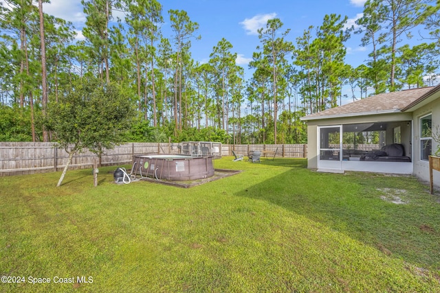 view of yard with a patio area, a fenced in pool, and a sunroom