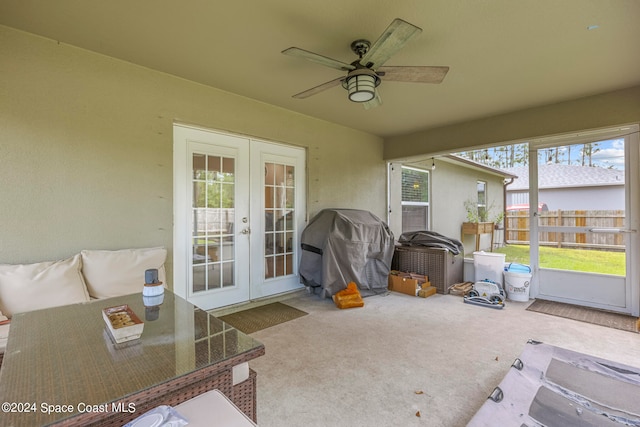 sunroom / solarium featuring french doors, plenty of natural light, and ceiling fan