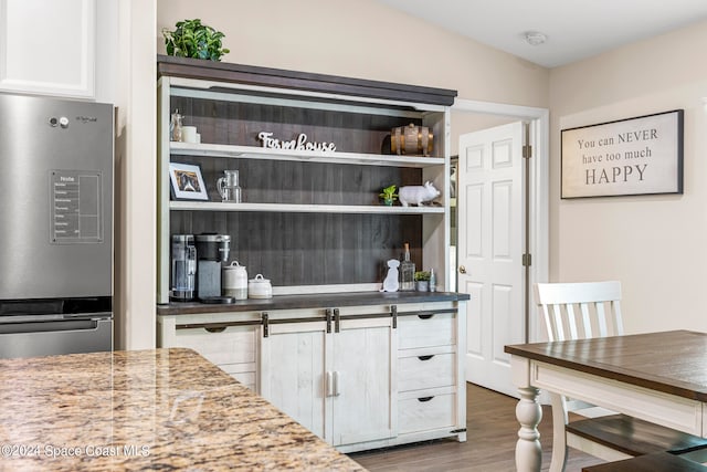 interior space featuring white cabinetry, dark stone countertops, and dark hardwood / wood-style flooring