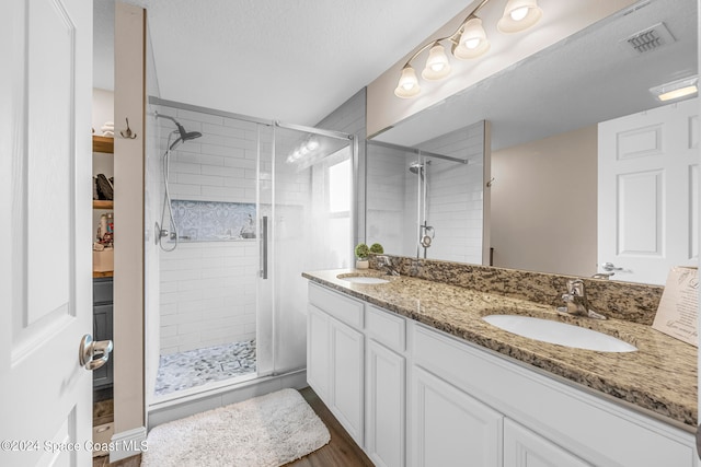 bathroom featuring vanity, a textured ceiling, an enclosed shower, and hardwood / wood-style floors