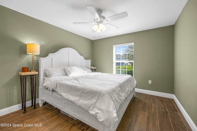 bedroom featuring a textured ceiling, dark wood-type flooring, and ceiling fan