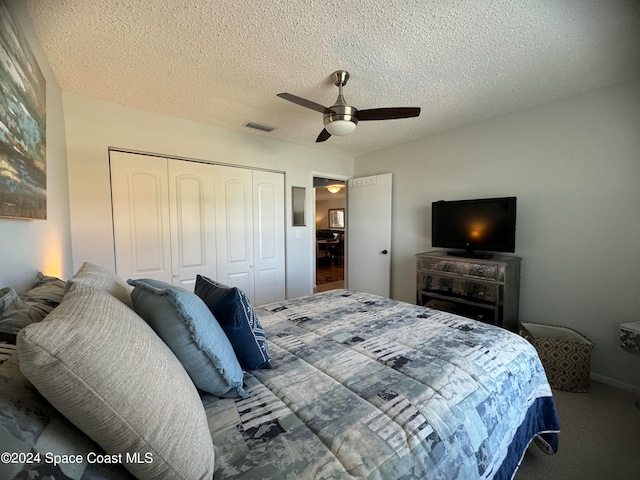 carpeted bedroom featuring a textured ceiling, a closet, and ceiling fan