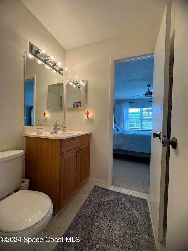 bathroom featuring toilet, tile patterned flooring, vanity, a textured ceiling, and ceiling fan