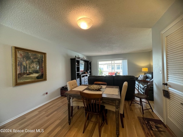 dining space featuring a textured ceiling and hardwood / wood-style flooring