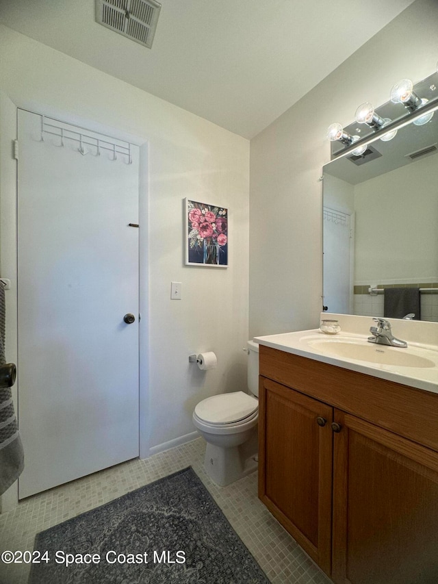 bathroom with vanity, toilet, and tile patterned floors