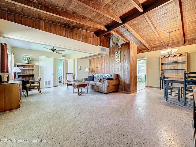 living room with wood walls, lofted ceiling with beams, wooden ceiling, and ceiling fan with notable chandelier