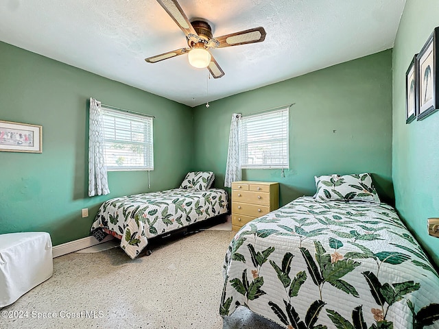 bedroom featuring multiple windows, a textured ceiling, and ceiling fan