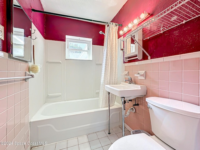 bathroom featuring tile walls, shower / bath combo with shower curtain, toilet, and tile patterned floors