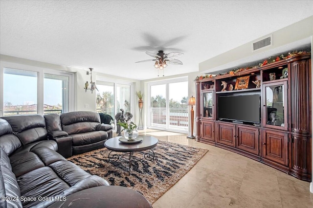 living room with ceiling fan and a textured ceiling