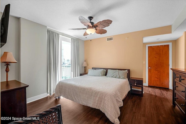 bedroom featuring a textured ceiling, ceiling fan, and dark wood-type flooring