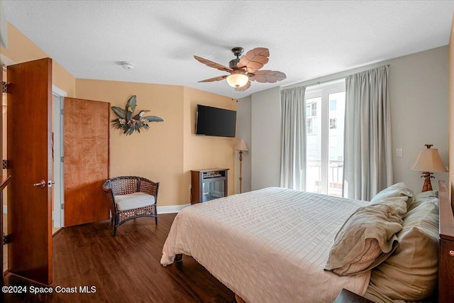 bedroom with ceiling fan, dark hardwood / wood-style flooring, and a textured ceiling