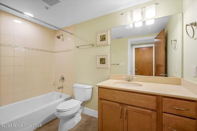 full bathroom with tile patterned floors, vanity, tiled shower / bath combo, and toilet