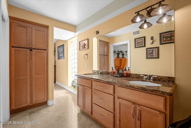 bathroom with vanity and a textured ceiling