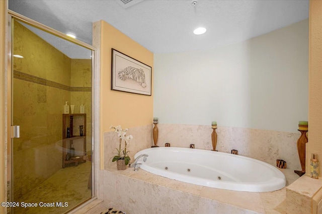 bathroom featuring separate shower and tub and a textured ceiling