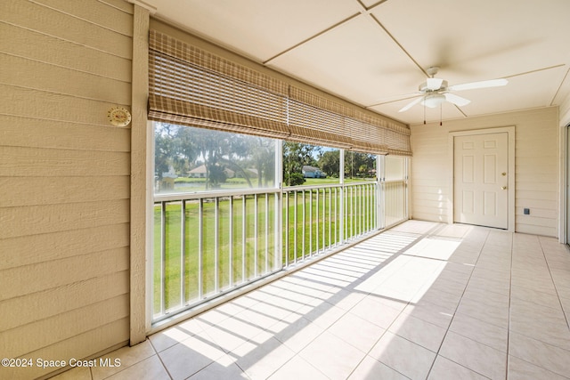 unfurnished sunroom featuring ceiling fan