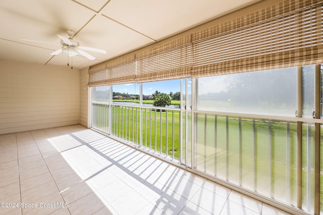 unfurnished sunroom featuring ceiling fan