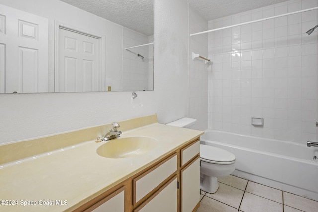 full bathroom featuring toilet, tile patterned flooring, tiled shower / bath combo, vanity, and a textured ceiling