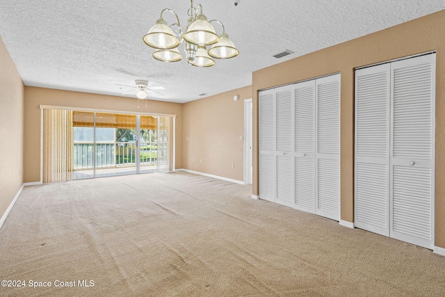 unfurnished bedroom with multiple closets, carpet, access to exterior, and ceiling fan with notable chandelier