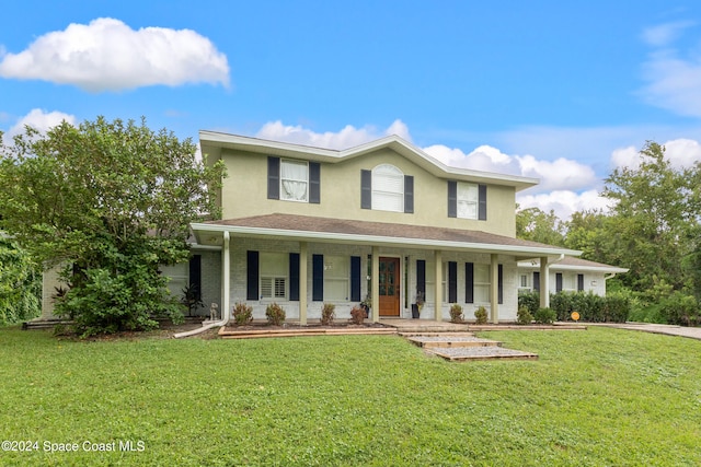 view of front of home featuring covered porch and a front lawn