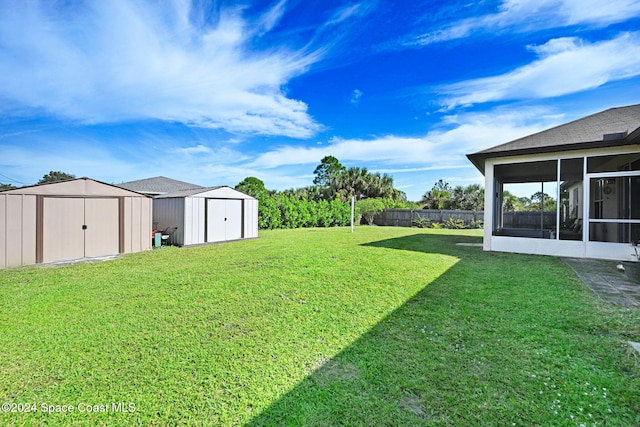 view of yard featuring a sunroom and a storage shed