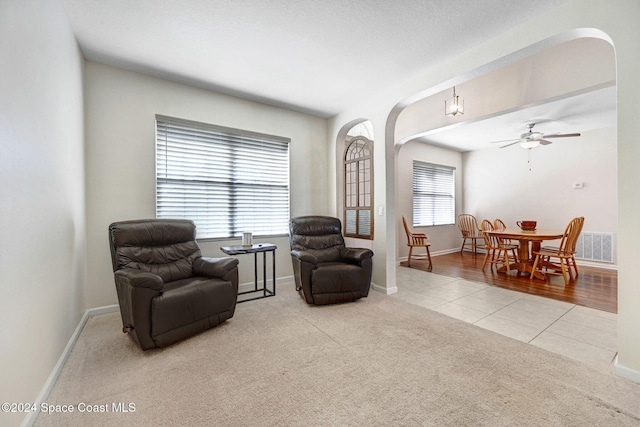 sitting room with ceiling fan and light hardwood / wood-style flooring