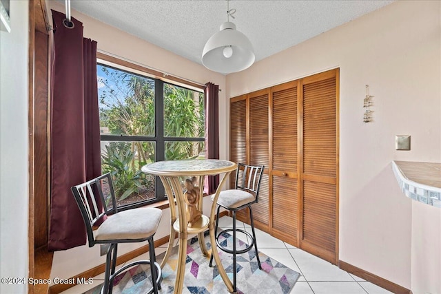 tiled dining area featuring a textured ceiling