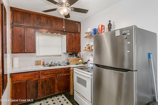 kitchen with electric stove, stainless steel refrigerator, sink, and ceiling fan