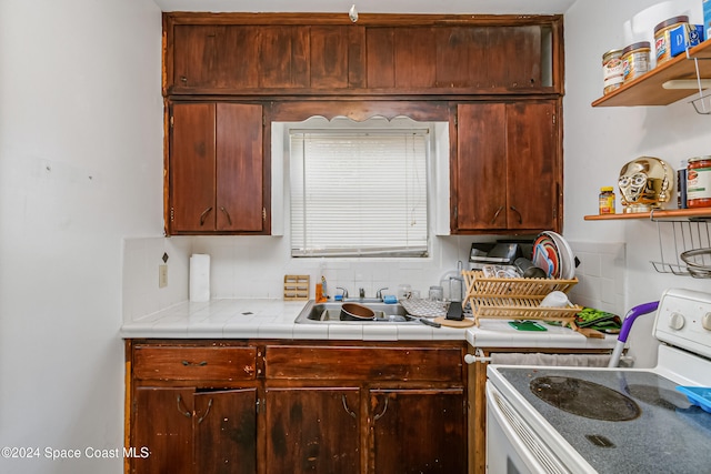 kitchen featuring sink, tile counters, and white range with electric stovetop