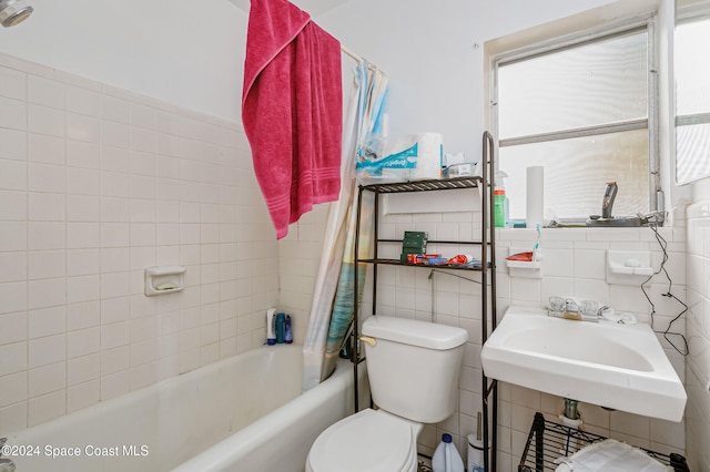 full bathroom featuring toilet, shower / tub combo with curtain, sink, and tile walls