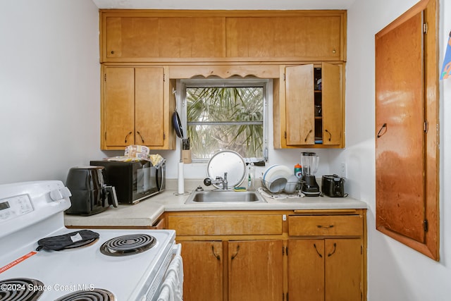 kitchen featuring white range with electric stovetop and sink