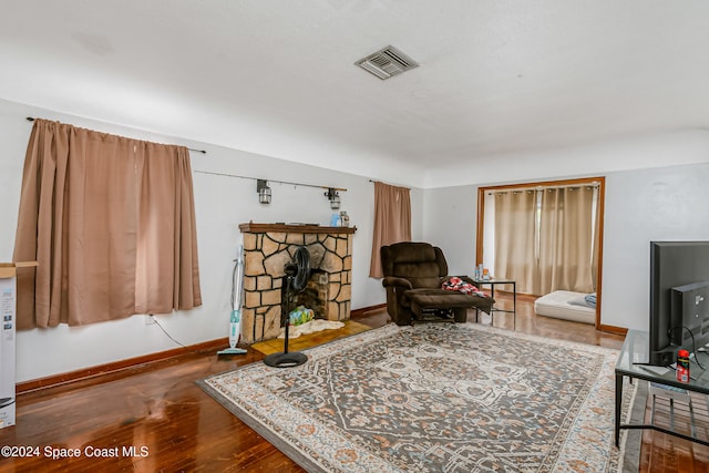 living area with a fireplace and wood-type flooring