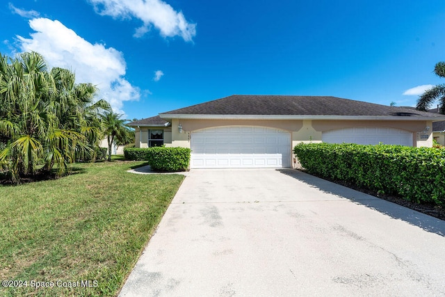 single story home featuring a front yard and a garage