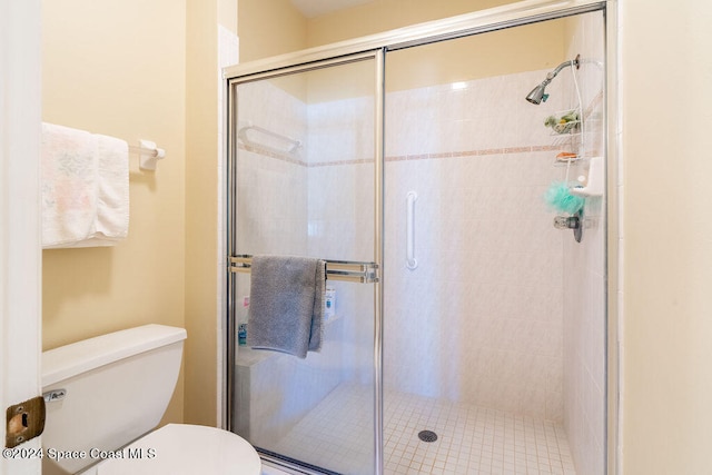 bathroom with toilet and a shower with shower door