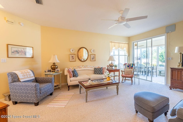 carpeted living room with ceiling fan