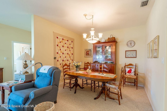 dining space featuring a chandelier and light colored carpet