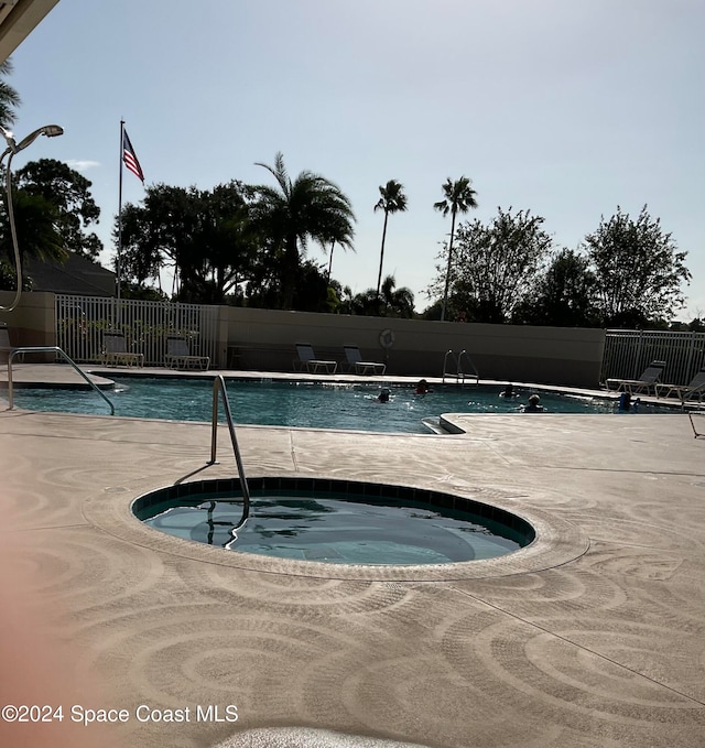 view of swimming pool with a community hot tub and a patio