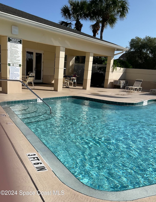 view of swimming pool featuring a patio and central air condition unit