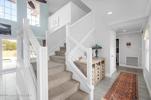 stairs featuring tile patterned floors and crown molding