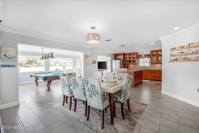 tiled dining area with sink, crown molding, and pool table