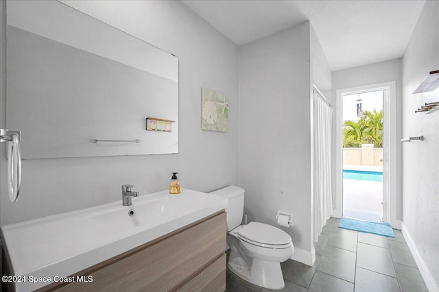 bathroom featuring toilet, vanity, and tile patterned floors